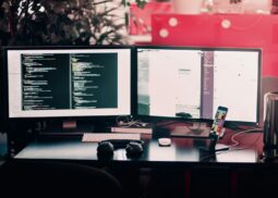 two black computer monitors on black table